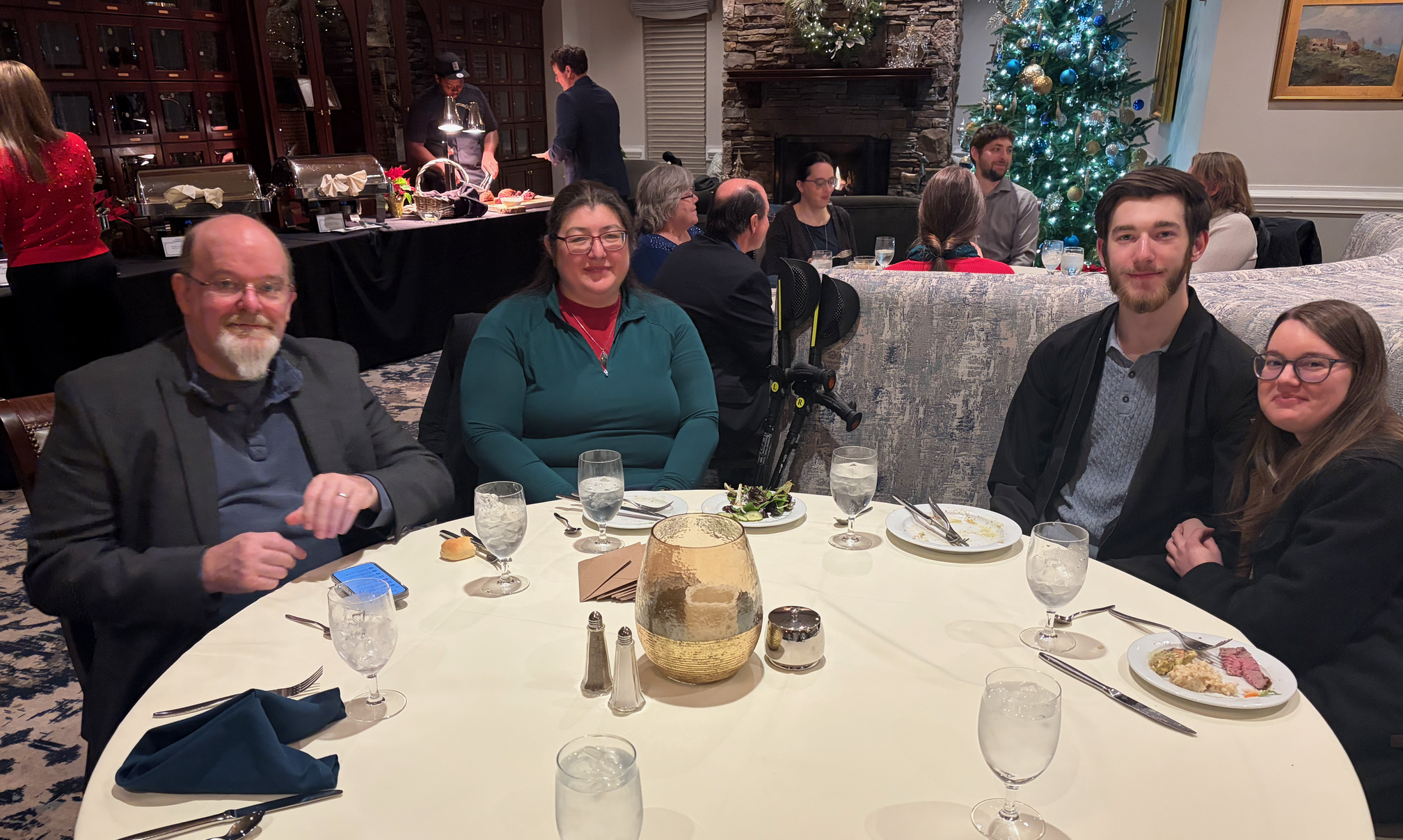 James, Mitake, Collin, and Sammy around a table. The buffet and another round table of Keystone staff are behind them.